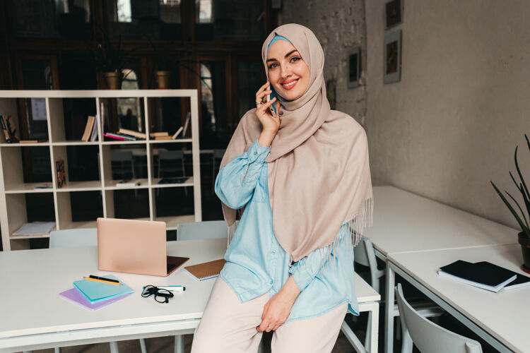 阿拉伯语年轻漂亮的现代妇女戴着头巾在办公室工作 在线教育互联网电话通信