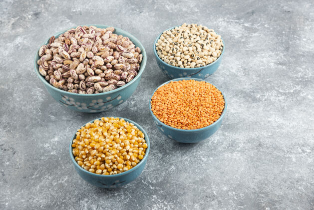 豆类一碗碗生豆子 小扁豆和玉米放在大理石表面干的种子烹饪