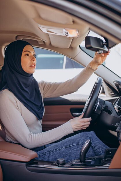 宗教年轻的妇女坐在车里照镜子围巾阿拉伯语自信
