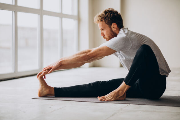姿势男人在家里的垫子上练习瑜伽锻炼健康禅宗