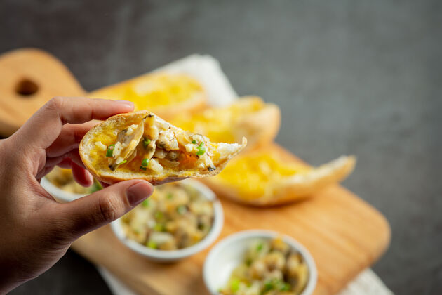 盘子烤蛤蜊配大蒜和黄油 配大蒜面包 背景颜色为深色美味海鲜美味
