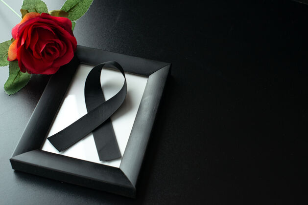 爱情黑色墙壁上带黑色蝴蝶结的相框俯视图相框丝带玫瑰