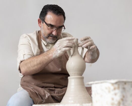中镜头中在做陶器工艺工匠艺术家