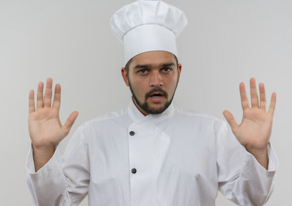 厨师年轻的男厨师穿着厨师制服 双手空空地孤零零地站在白色的墙上年轻空制服