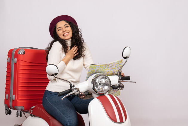 摩托车正面图年轻女性骑自行车手持地图在白色背景上城市彩色道路上度假车骑摩托车速度快微笑举行骑
