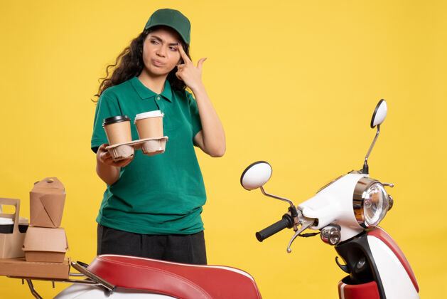 高尔夫球手正面图身着绿色制服的女快递员 背景为咖啡色 背景为黄色 服务人员工作 工作 食物 女性颜色工人服务工作
