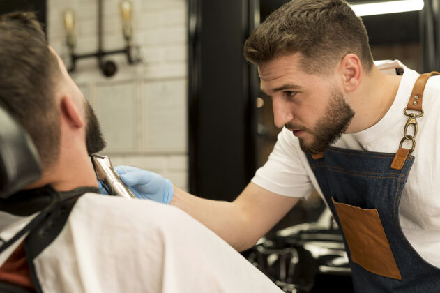 男人在理发店理胡子的年轻人就业理发师修剪