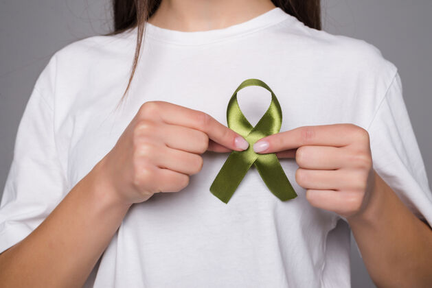 白天绿色丝带象征肾癌隔离在灰色的墙上循环疾病骄傲