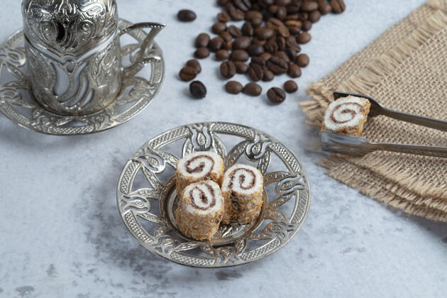 卷美味的甜面包卷 咖啡豆和土耳其咖啡的石头背景高品质的照片民族青铜豆子