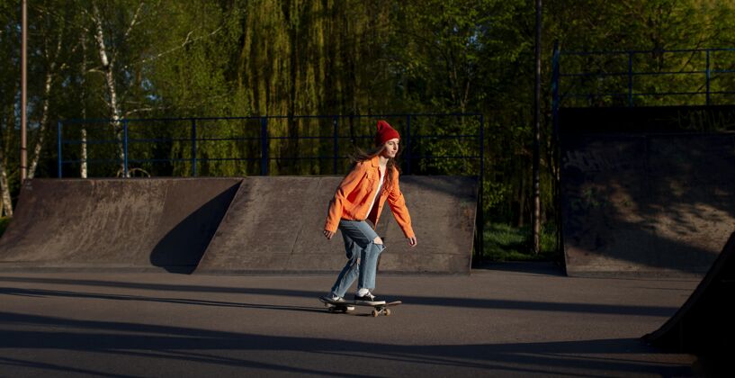 女孩一个在外面玩滑板的年轻女孩溜冰生活方式运动