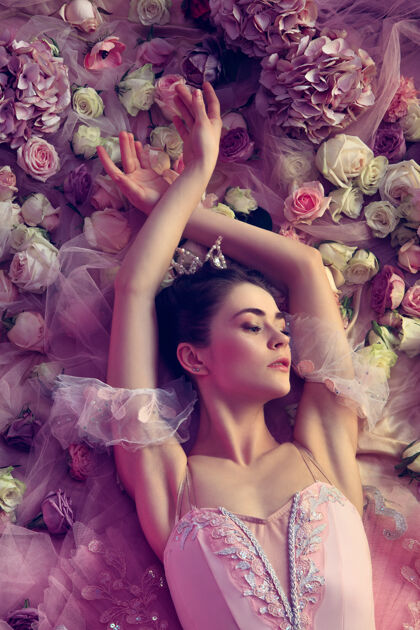 经典俯瞰美丽的年轻女子在粉红色芭蕾舞团图图周围的鲜花服装优雅姿势
