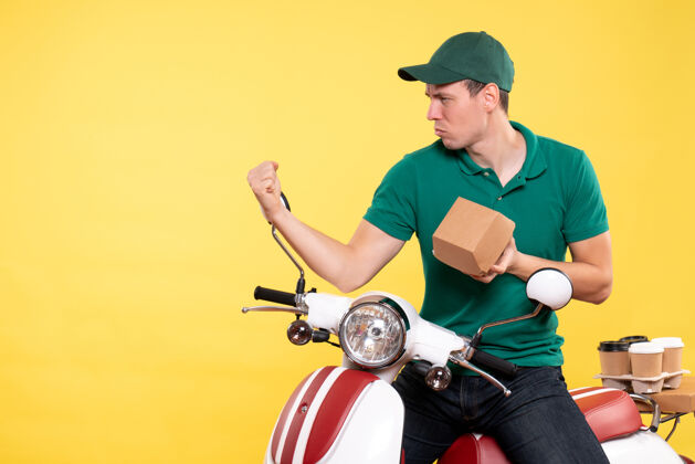 工作正面图穿着制服的男信使拿着黄色的小食品包摩托车输送机男快递员