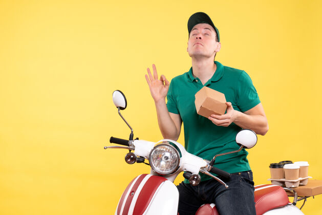 男快递正面图穿着制服的男信使拿着黄色的小食品包快餐车辆摩托车