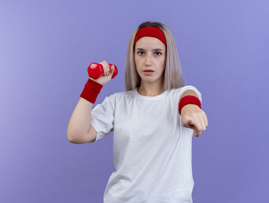 尖自信的年轻白人运动女孩戴着背带和头带信心头带背带