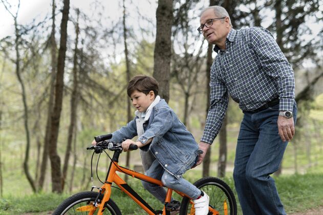 自行车爷爷教他的孙子怎么骑自行车老人男性公园