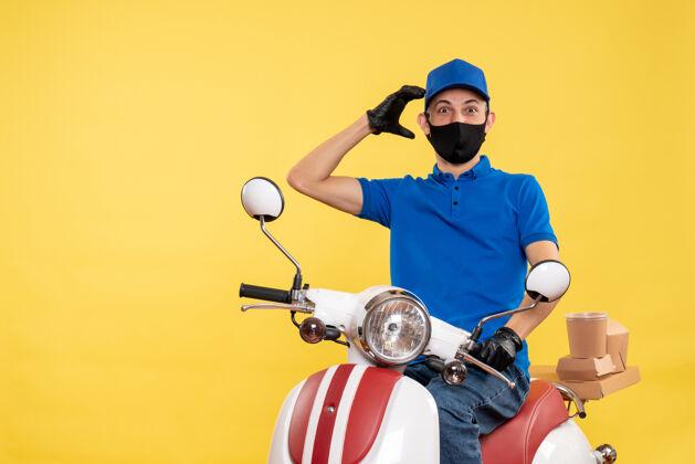 送货正面图身着蓝色制服的年轻男性快递员在黄色背景下工作-工作递送服务病毒自行车男人人摩托车