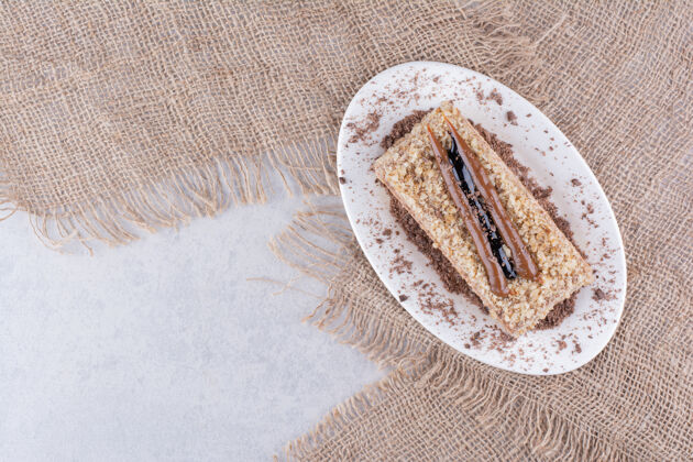 自制美味的蛋糕放在白色的盘子里 上面有粗麻布块甜点糕点
