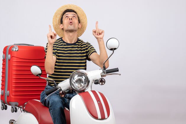 男人正面图：一个戴着草帽的年轻人指着天花板轻便摩托车车辆人