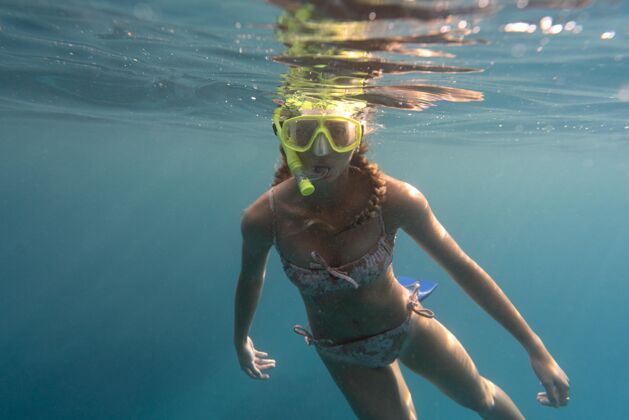 水戴着潜水器在海里游泳的女人游泳水下女子