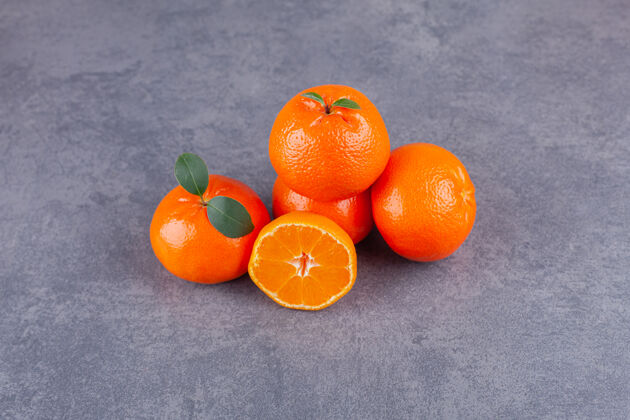 美味整个和切片的橘子叶放在石桌上国语美味橘子