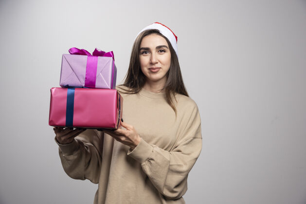 表情年轻女子拿着两盒圣诞礼物圣诞老人年轻女性