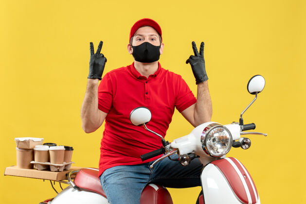 医疗俯视图：快递员身穿红色上衣 戴着帽子手套 戴着医用面罩 坐在滑板车上做着胜利手势摩托车摩托车手套