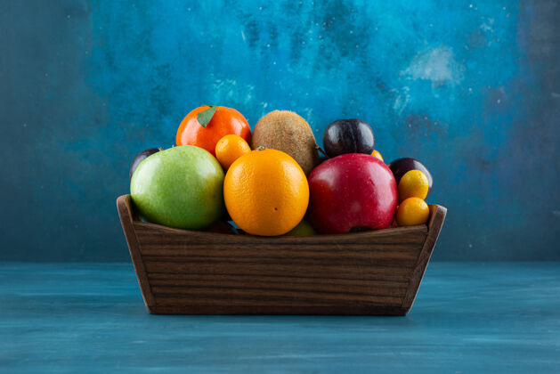 苹果蓝色表面上装满各种有机水果的木箱天然生的健康