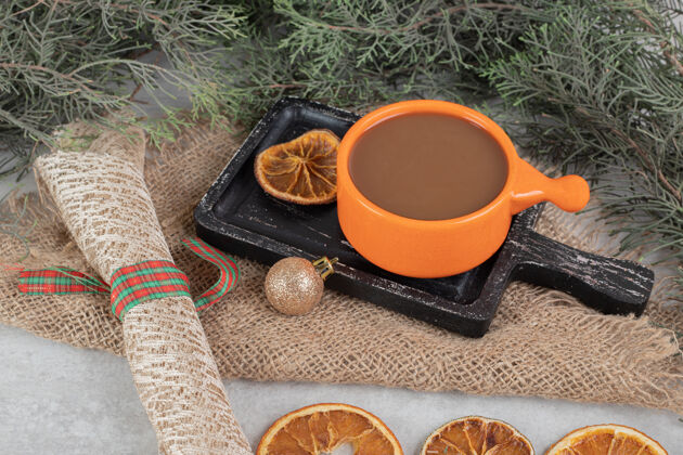 杯子咖啡和橘子片放在深色的木板上 还有圣诞装饰美味切片营养