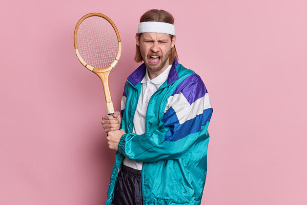 运动不高兴的男网球手拿着球拍心烦意乱地输掉比赛 穿着运动服做不高兴的鬼脸球拍专业恼怒