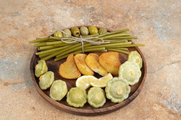 配料把腌橄榄 绿豆和炸土豆放在木盘上一餐美味土豆