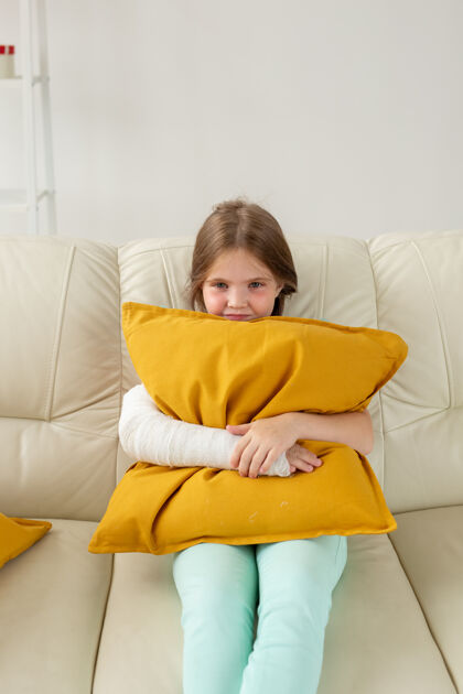 孩子坐在沙发上手腕或胳膊骨折的孩子医学肖像微笑
