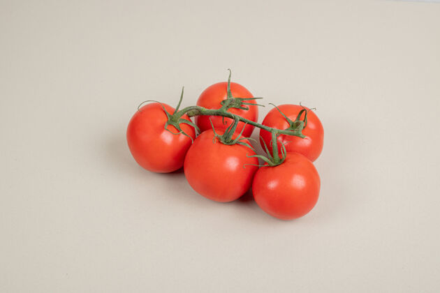 蔬菜在白色的桌子上放着一堆新鲜的红番茄和绿茎叶子束有机