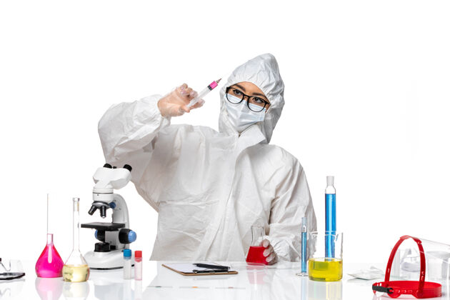 面具前视图穿着特殊防护服的女化学家在白色背景的covid化学病毒实验室工作专业正面女化学家