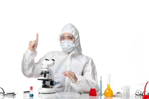 人前视图：女医生穿着防护服 戴着口罩 在白色背景下使用显微镜观察病毒大流行 病毒是病毒防护男人白人