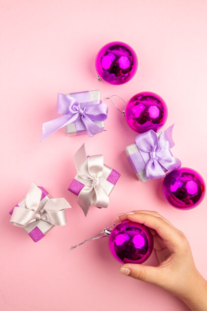 花顶视图的小礼物与圣诞树玩具在粉红色的表面圣诞节春天宝石