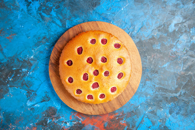水蓝色表面木板上草莓蛋糕的俯视图玻璃食物草莓蛋糕