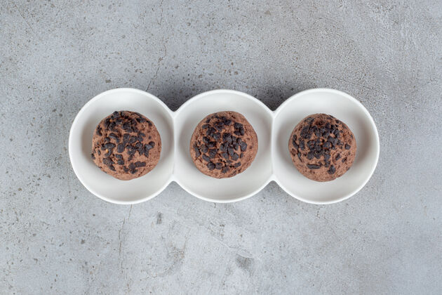 甜点巧克力饼干放在大理石桌上的盘子里巧克力美味薯片