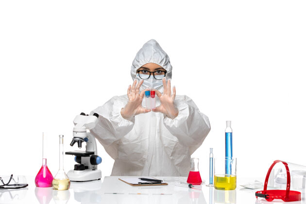 套装正面图穿着特殊防护服的女化学家拿着白色背景上的空烧瓶病毒健康化学冠状病毒外套化学前面