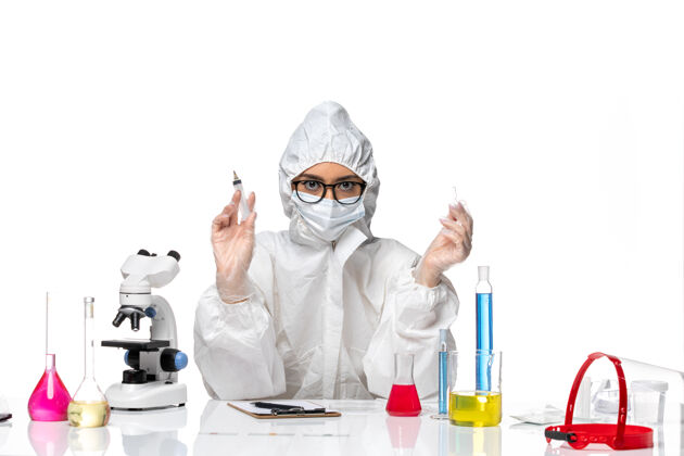 健康正面图身着特殊防护服的女化学家手持白色背景上的注射化学冠状病毒大流行注射药品正面