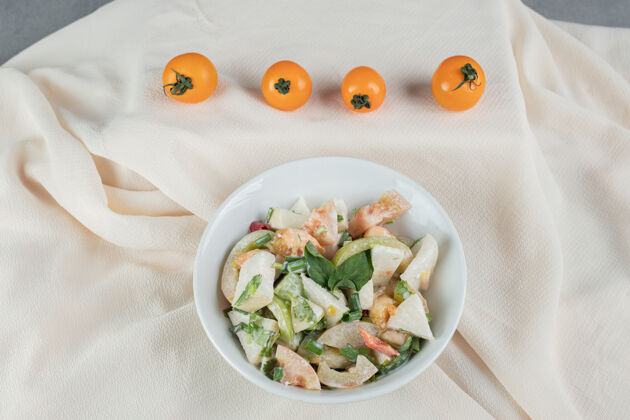 晚餐混合配料的时令沙拉 蔬菜和水果放在一个白色的盘子里餐具自制剁碎