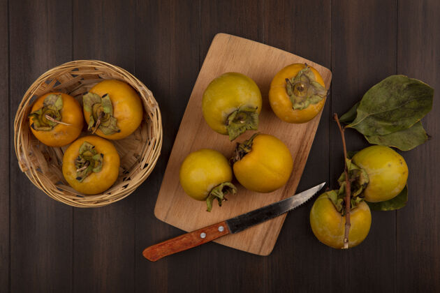 厨房有机柿子水果在木桶上的俯视图 柿子水果放在木制厨房板上 刀放在木桌上新鲜食品有机
