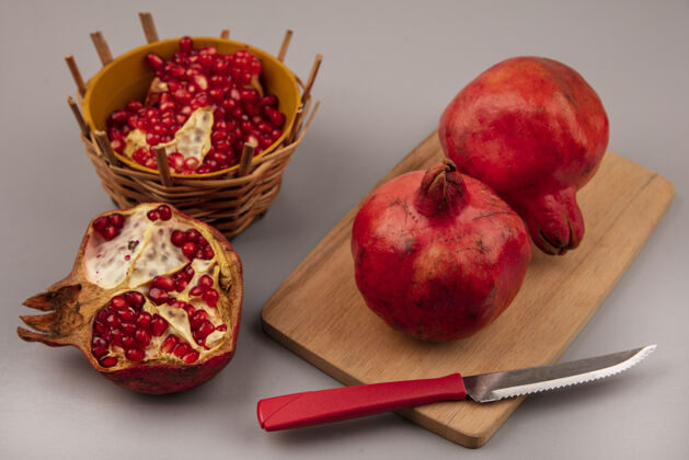 刀木制菜板上的美味红石榴俯视图 刀子上放着石榴籽厨房碗食物