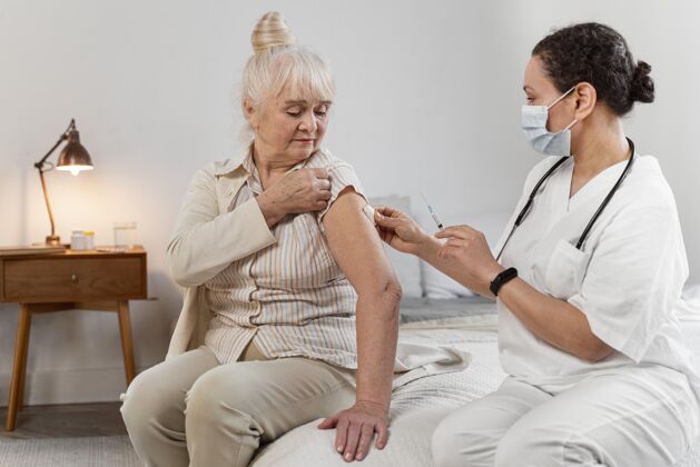 室内医生正在为一位老年妇女准备疫苗健康老年人房子