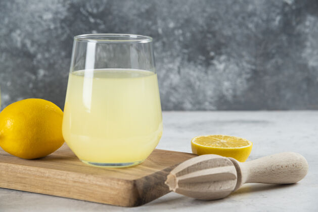 黄色一杯柠檬水和木铰刀酸果汁有机
