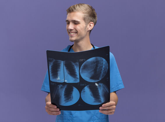 男性微笑着看着身边年轻的男医生穿着医生制服手持听诊器的x光隔离在蓝色的墙上微笑听诊器壁板