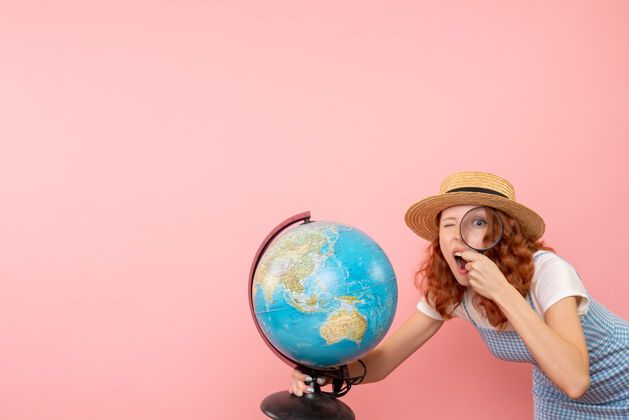 全球前视图女性游客用放大镜探索地球仪世界成人女人
