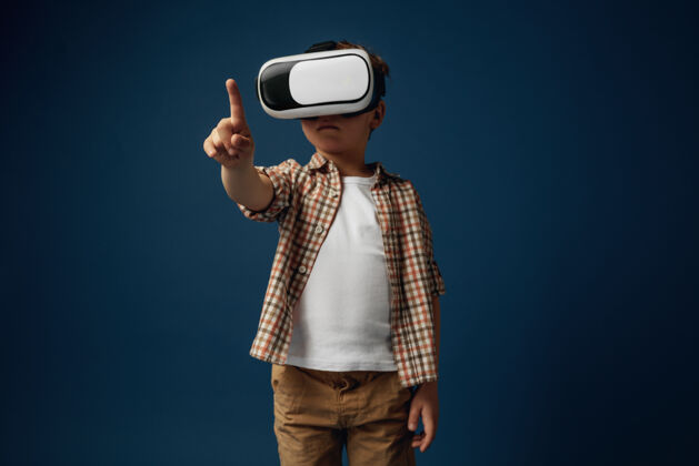 软件新的想法和情感小男孩或小孩用虚拟现实的眼镜指着空白的空间 隔离在白色的工作室背景上概念尖端的技术 视频游戏 创新护目镜游戏创新