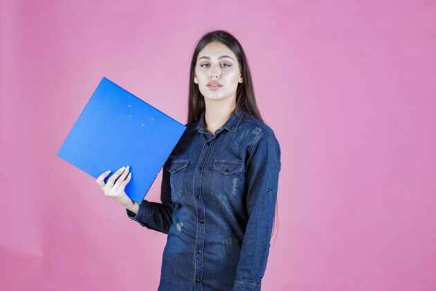 成人女商人拿着一个蓝色的文件夹自信女人报告女人