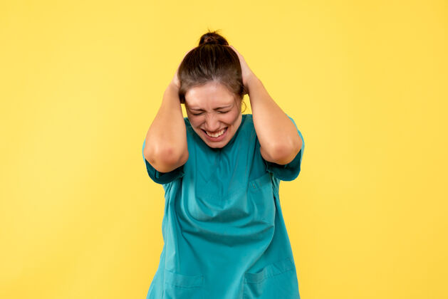 女医生前视图黄色背景上穿着医用衬衫的女医生肖像成人护士