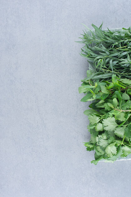 五颜六色灰色石头背景上的绿色草药组合蔬菜新鲜自然